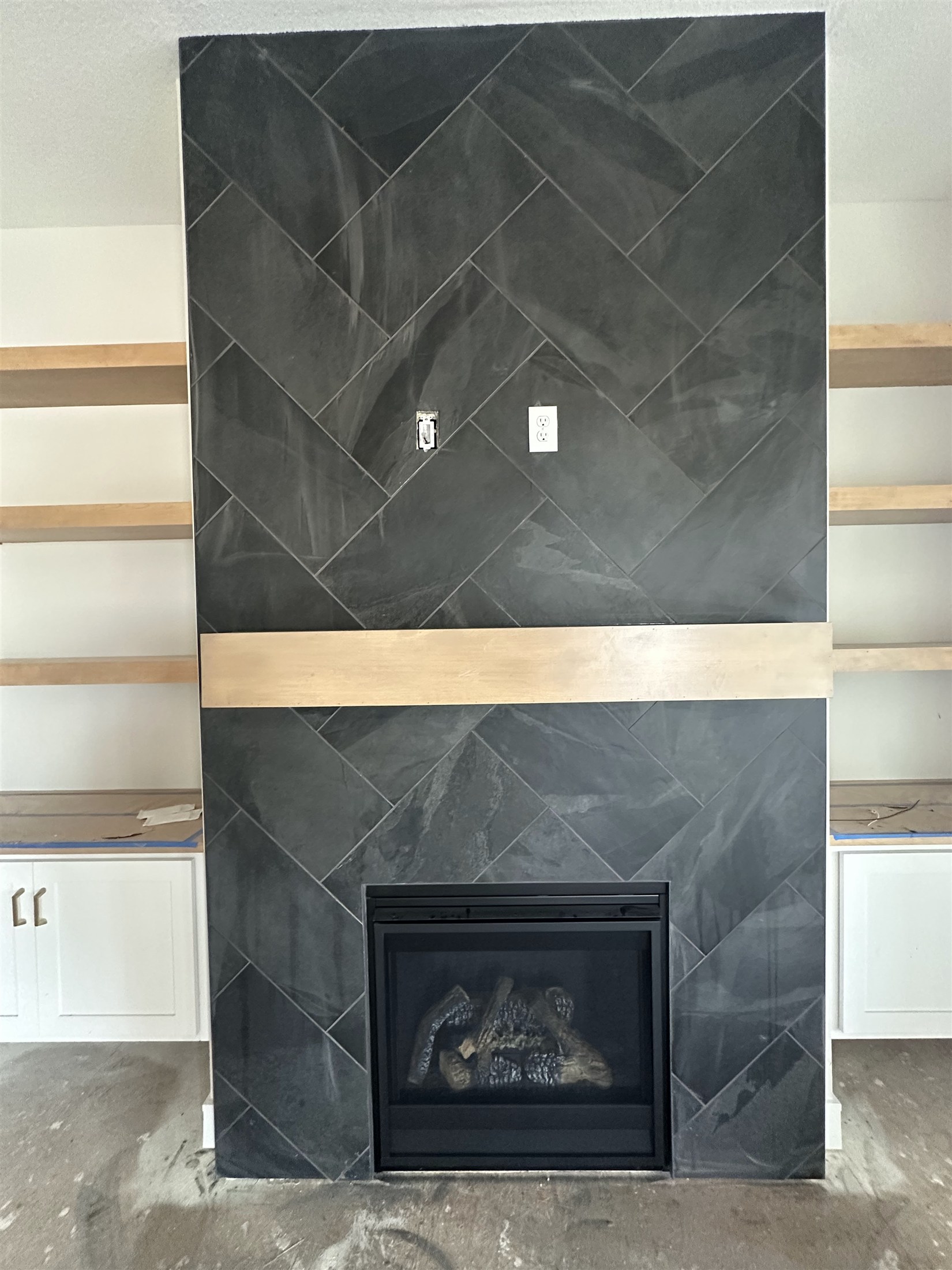 Dark tile fireplace surround installed by Heartland Tile