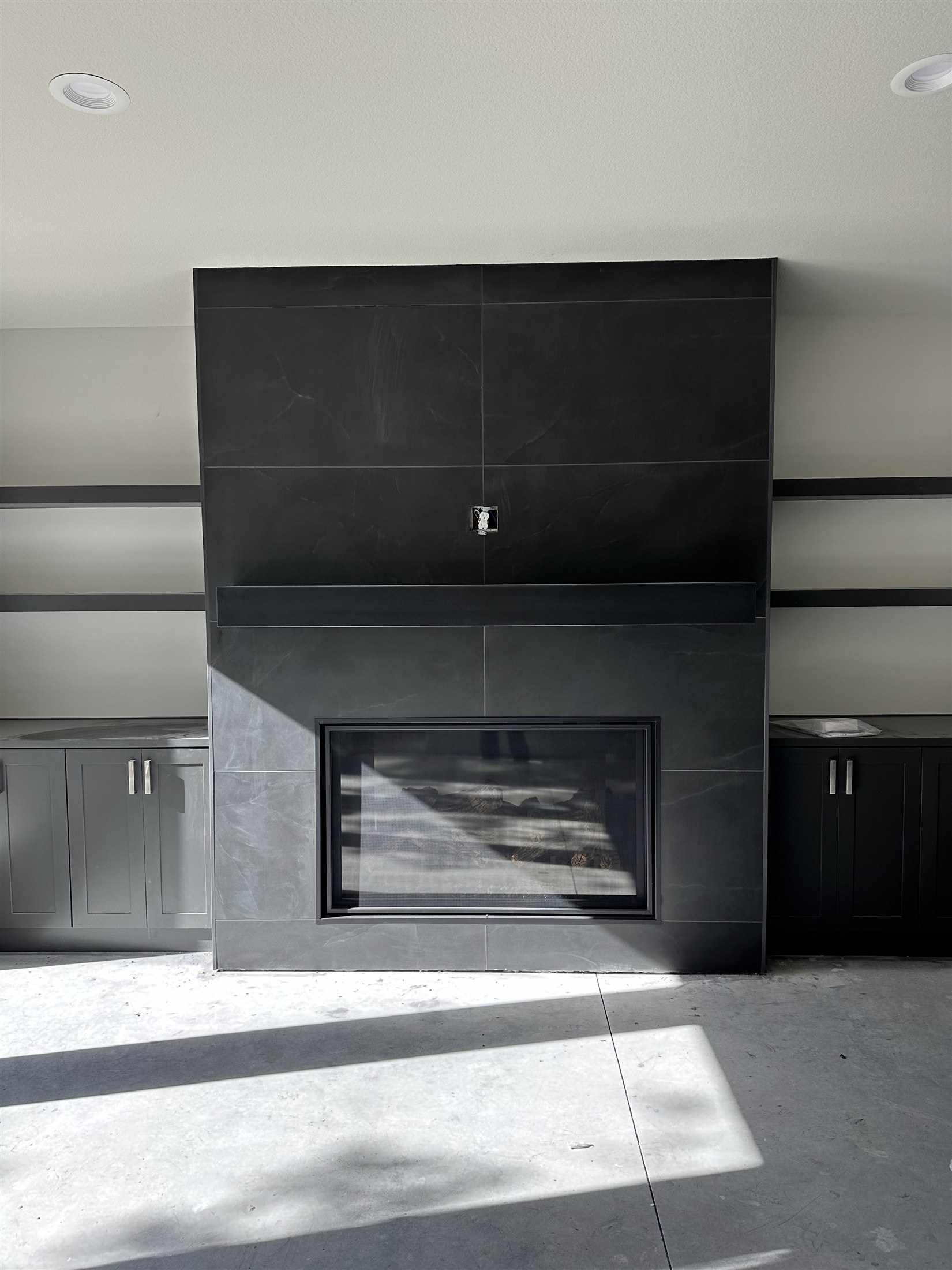 Modern dark tile fireplace installed by Heartland Tile