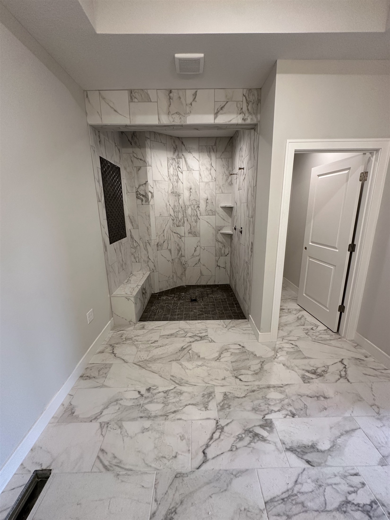 Marble-look bathroom floor installed by Heartland Tile